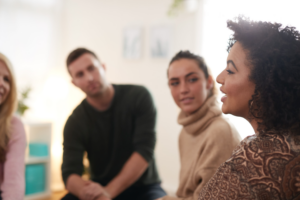 A group of four people is talking in a support group. 